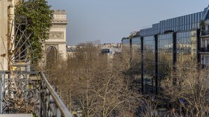 A view of the Arc de Triomphe with a modern building in the background. - Luxury 5 Bed Residence - Opposite Arc de Triomphe (Paris)