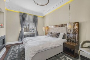 Una camera da letto moderna con un letto grande, un comodino, una testiera decorativa e vista all'esterno da una finestra.