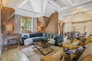 A spacious living room with a sectional sofa, a glass coffee table, and a dining area with a table and chairs. - Mayfair Home Central AC Huge Terrace (London)