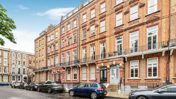 A row of terraced houses with a street in front. - Stylish 1BR Kensington Home With Balcony (London)