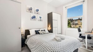 Une chambre à coucher avec un lit, un bureau et une fenêtre.