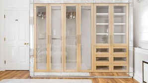 Un closet amplio con puerta espejada, estantes de madera y espacio para colgar ropa.