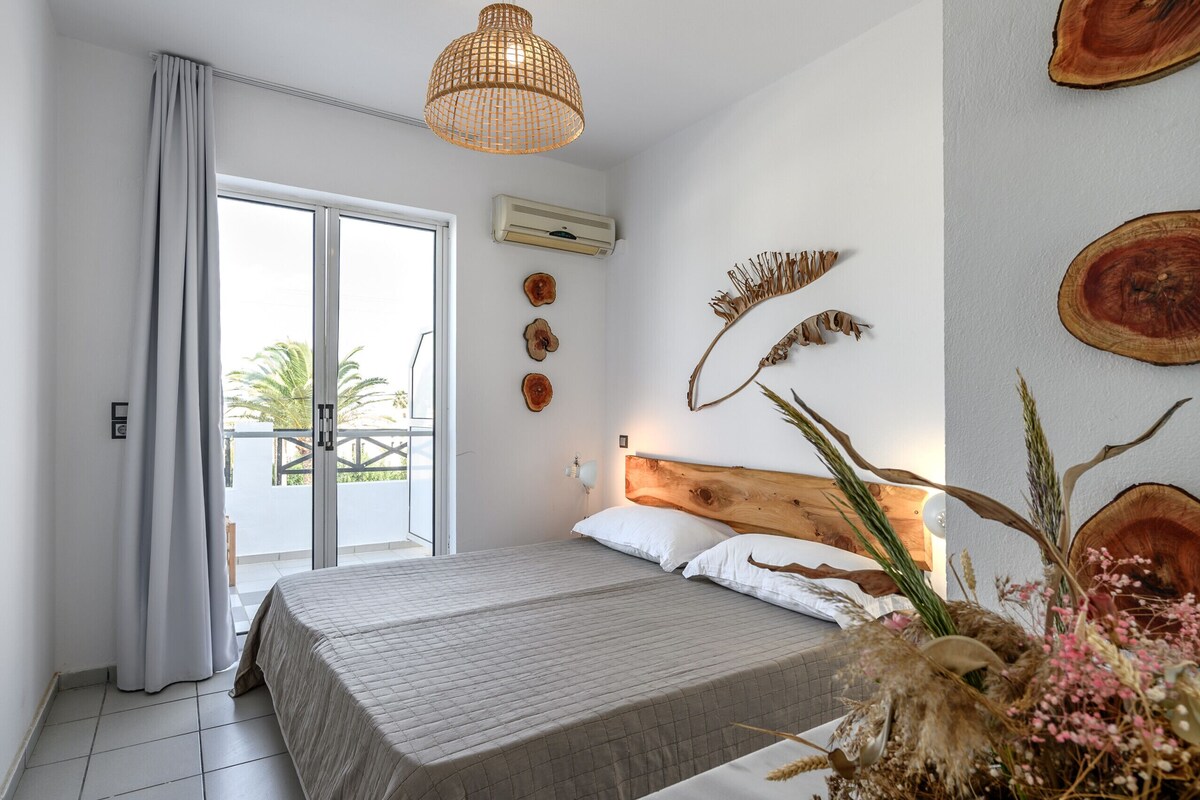 Un dormitorio con cama, una lámpara de techo y vistas al exterior.