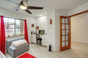 A modern living room with a grey sofa, a red rug, a desk with a computer, and a window with red curtains. - Sip, Hike, Relax! Cottonwood Home 4 Mi to Old Town (Cottonwood)