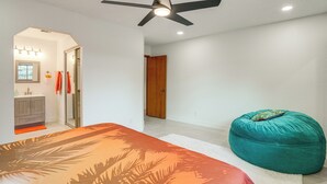 A bedroom with a bed, a teal bean bag, a ceiling fan, and a bathroom visible through an archway. - Sip, Hike, Relax! Cottonwood Home 4 Mi to Old Town (Cottonwood)
