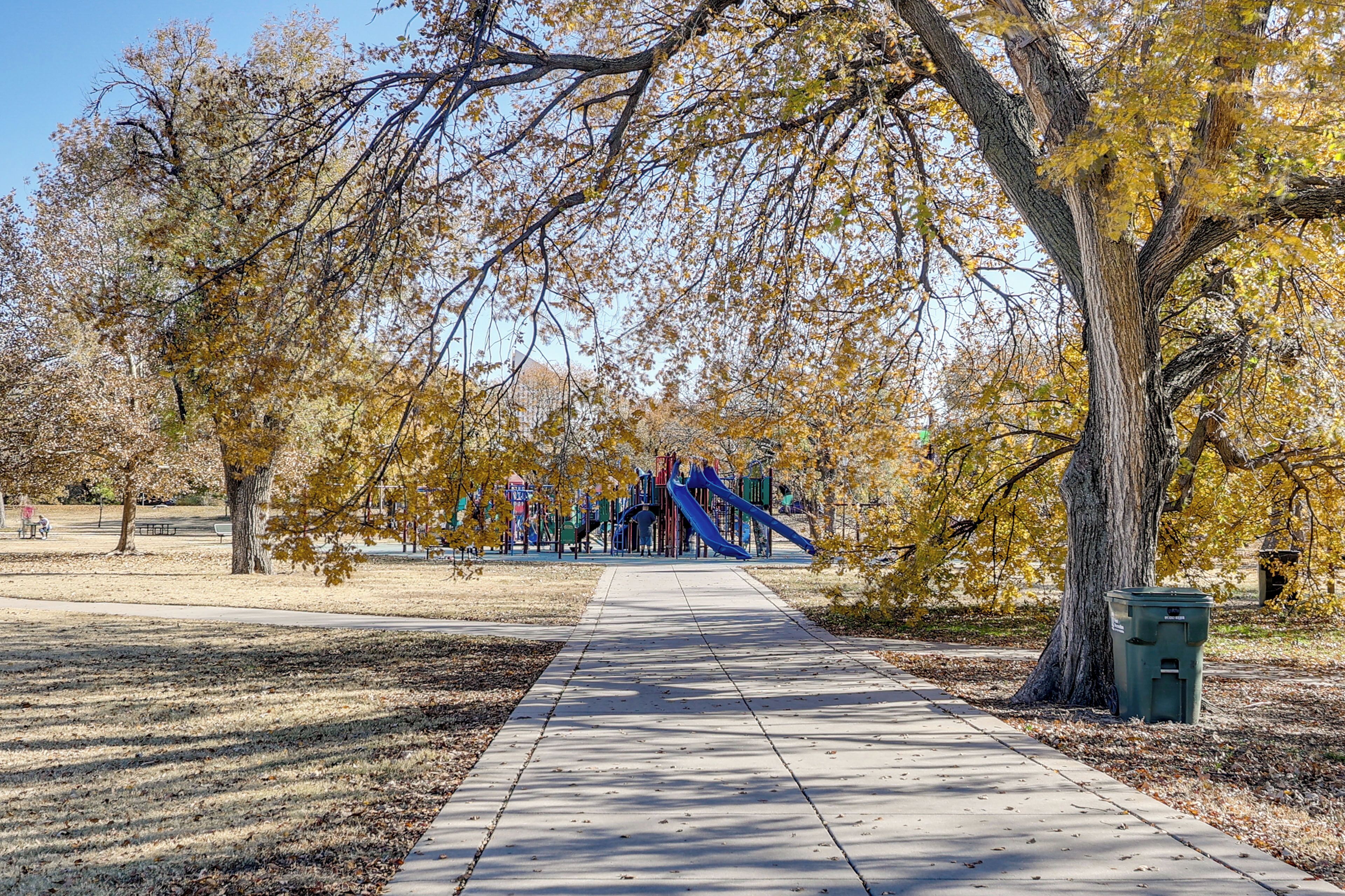 A park pathway leading to playground equipment.