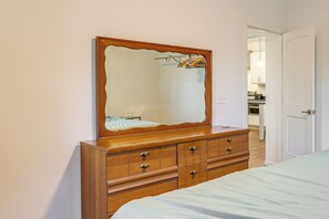 Ein Schlafzimmer mit einem Holzkapfen, einem großen Spiegel und einem Bett.