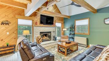 Una sala de estar acogedora con chimenea, sofás de cuero y televisor.