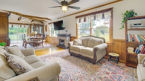 A cozy living room with a fireplace, a ceiling fan, and a bookshelf. - Walk to Dtwn Warsaw: Family Home w/ Deck! (Warsaw)