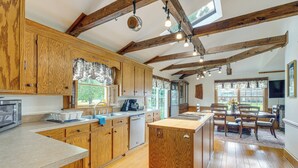 A spacious kitchen with wooden cabinets, a central island, and a dining area with chairs and a table. - Walk to Dtwn Warsaw: Family Home w/ Deck! (Warsaw)