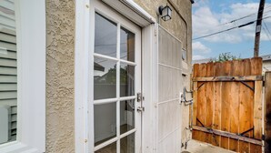 Una porta garage bianca con una recinzione in legno e un corpo illuminante sopra.