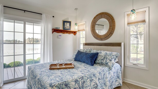 A bedroom with a large bed, a round mirror, and a view of the outdoors. - 2 Mi to Dtwn! Waterfront Gem on Wicomico River (Salisbury)