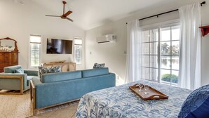 A spacious bedroom with a large bed, a blue sofa, a wooden dresser, and a flat-screen TV on the wall. - 2 Mi to Dtwn! Waterfront Gem on Wicomico River (Salisbury)