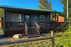 A building with a porch, a staircase, and a fenced area. - Trail Town Usa! 2BD Cabin on Laurel Creek w/ Deck (Damascus)