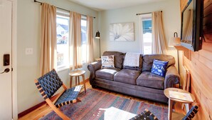 A cozy living room with a brown leather sofa, a patterned rug, and a small wooden table. - Trail Town Usa! 2BD Cabin on Laurel Creek w/ Deck (Damascus)