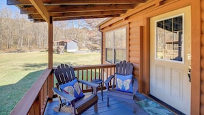 A wooden porch with two Adirondack chairs and a small table. - Pet-friendly Damascus Cabin w/ Deck & Mtn Views! (Damascus)