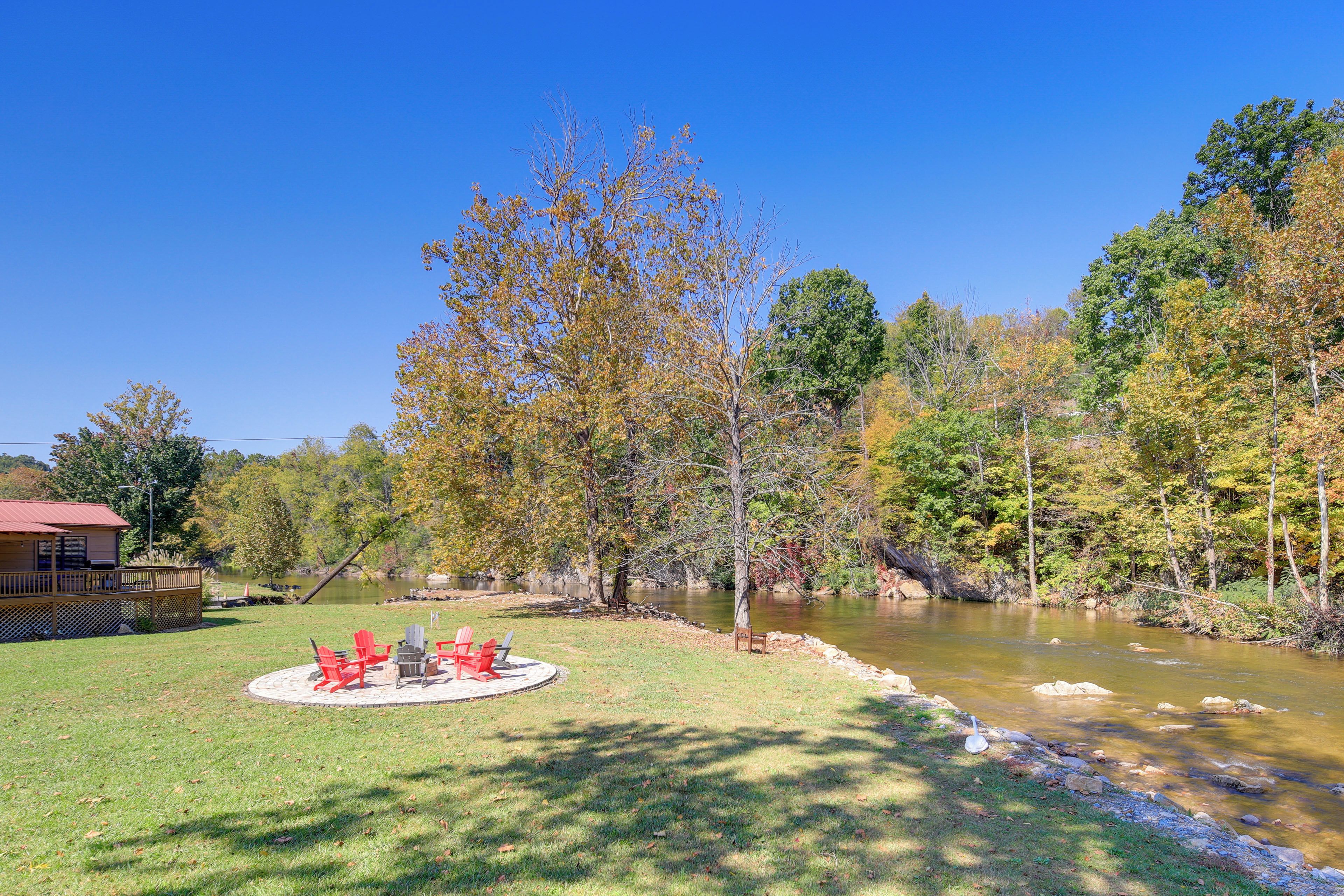 A riverside property with a deck and outdoor seating area.