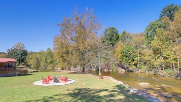 A riverside property with a deck and outdoor seating area.