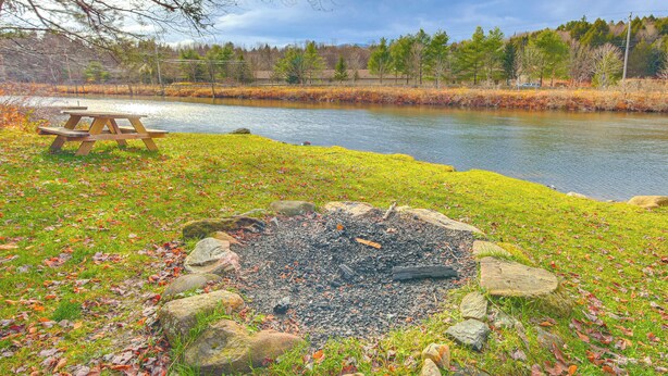 A picnic table and a fire pit by a lake with a forest in the background. - Ludlow Cabin on Lake Pauline w/ Outdoor Fire Pit (Ludlow)