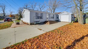 A single-story mobile home with a front porch and a small deck. - Walk to Houghton Lake! Family Retreat w/ Patio (Houghton Lake Heights)