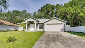 A single-story house with a garage, a front lawn, and a driveway. - Spacious Home w/ Yard: 8 Mi to Wabasso Beach (Sebastian)