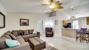 A spacious living room with a sectional sofa, a recliner, and a kitchen area with a bar. - Spacious Home w/ Yard: 8 Mi to Wabasso Beach (Sebastian)