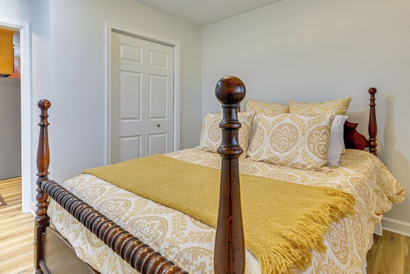Una cama con dosel de madera y un edredón amarillo.