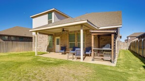 A two-story house with a covered patio area, a brick exterior, and a fenced backyard. - Close to Energy Giants! 3,300-sq-ft Midland Home (Midland)