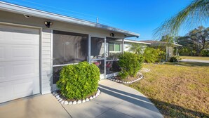 Une maison moderne à deux étages, dotée d’un garage, de grandes fenêtres et d’une pelouse bien entretenue.