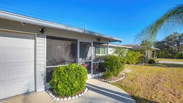 A modern two-story house with a garage, large windows, and a well-maintained lawn.