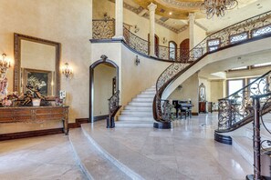 A grand foyer with a marble staircase, ornate columns, and a large mirror. - Grand 9,000-sq-ft Estate! Luxurious Socal Getaway (La Mesa)