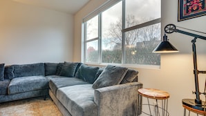 A modern living room with a grey sectional sofa, a round wooden coffee table, and a floor lamp. - Condo 6 Mi to Lumen Field & Dtwn Seattle! (Seattle)