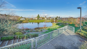 A park with a pond, a bridge, and a pathway. - Condo 6 Mi to Lumen Field & Dtwn Seattle! (Seattle)