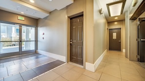 A hotel lobby with a glass door entrance, a brown door, and a tiled floor. - Condo 6 Mi to Lumen Field & Dtwn Seattle! (Seattle)