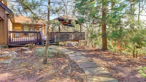 A wooden cabin with a deck and a covered outdoor seating area surrounded by trees. - Game Room & Resort Perks! Split Rock Retreat (Lake Harmony)