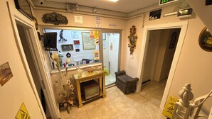 A reception area with a reception desk, a small seating area, and a door leading to the reception. - Meydan Pansiyon (İstanbul)