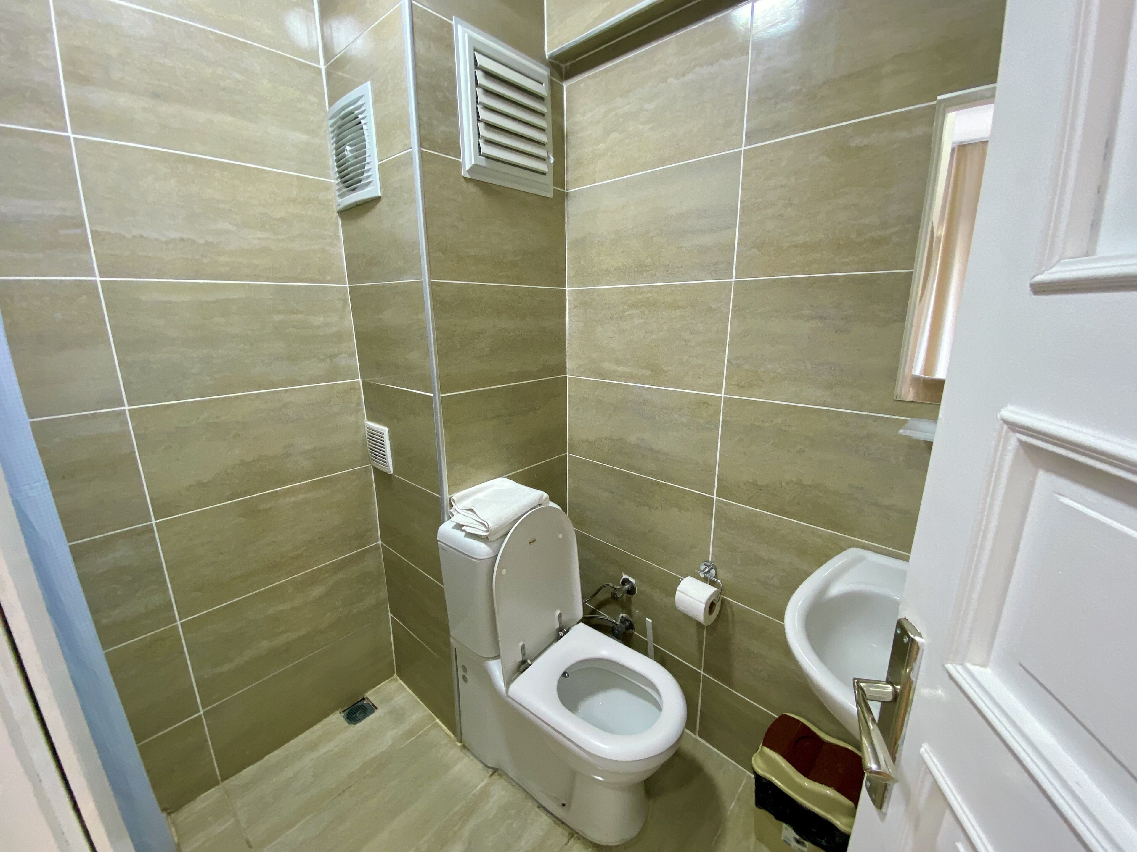 Un baño con inodoro, bidé y lavamanos, todo en color blanco.