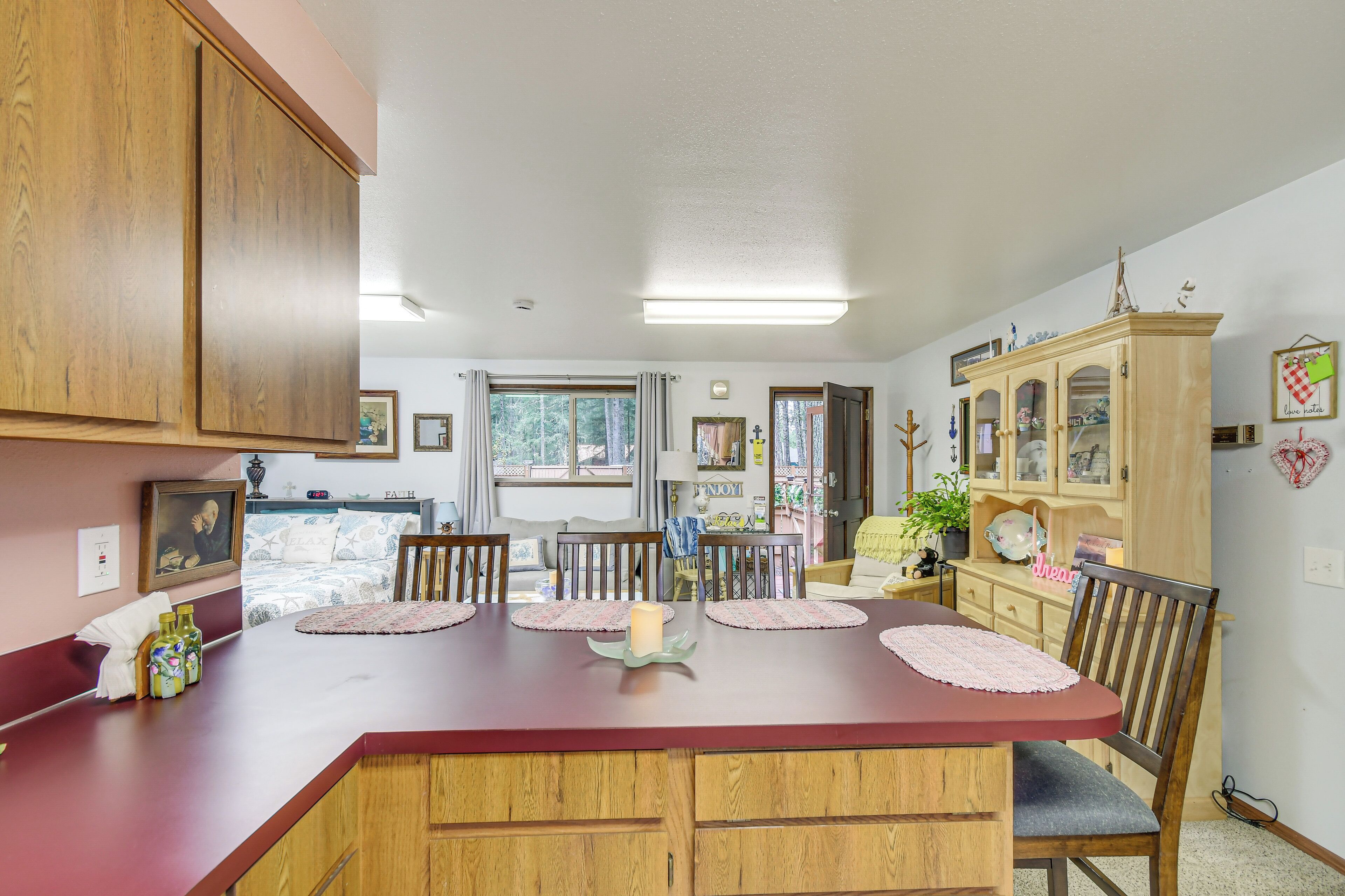 A dining area with a wooden table, chairs, and a cabinet with glass doors.