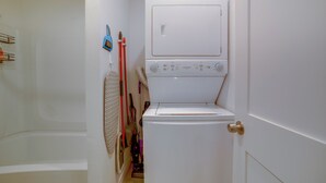 A laundry room with a washing machine and dryer, a broom, and a vacuum cleaner. - Nurse-ready Rental 10 Mi to Dtwn Riverside! (Moreno Valley)