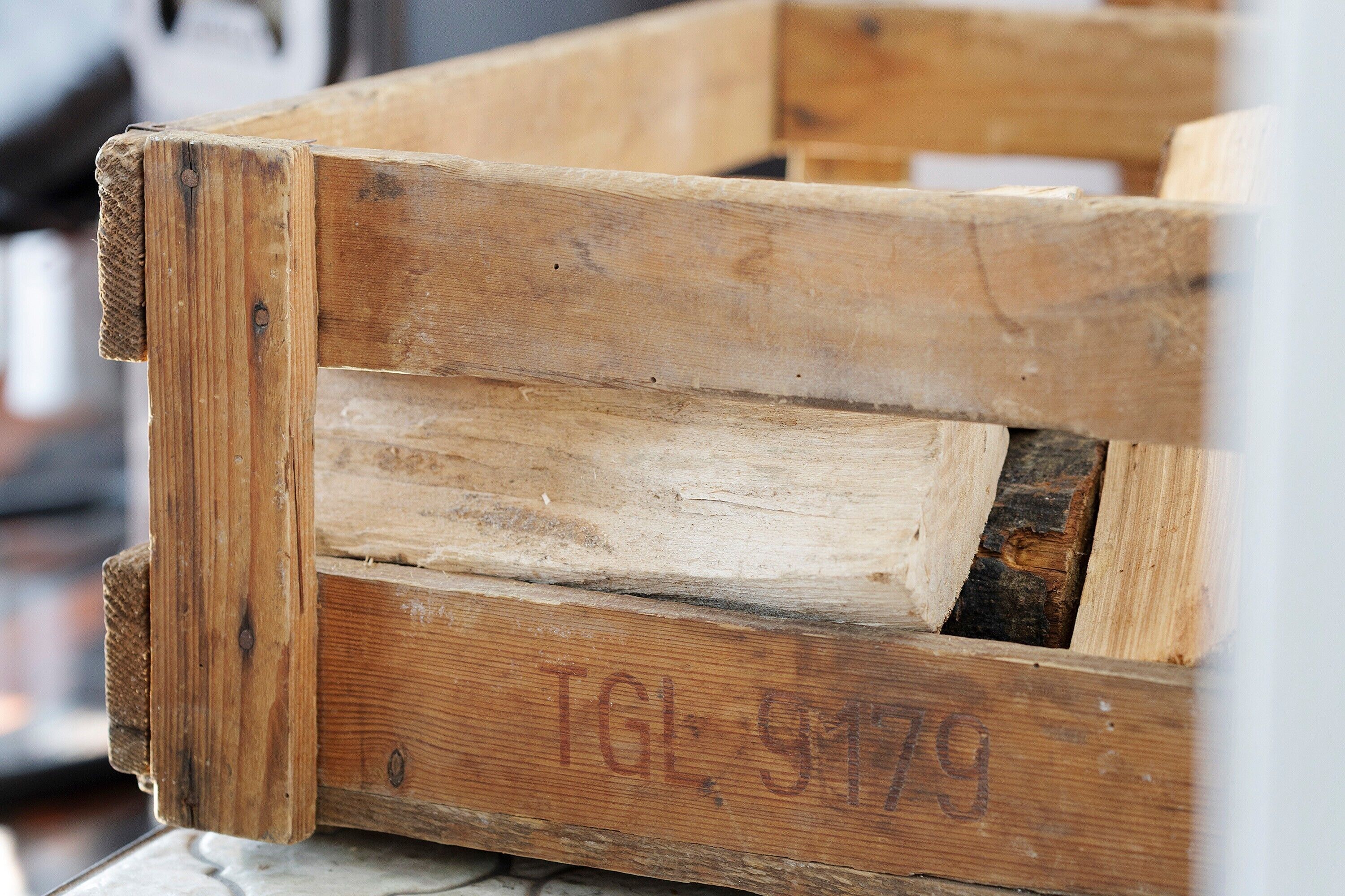 Una caja de madera con signos de uso y una etiqueta que dice 'TGL 9179'.