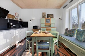 Una cocina compacta con una mesa y sillas, microondas, cafetera y ventana con vistas.