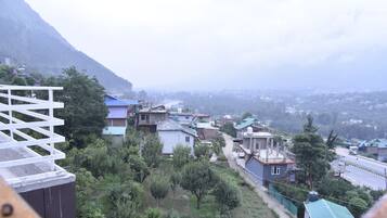 A residential area with houses, a road, and a mountain in the background.
