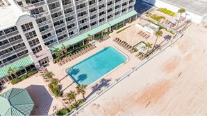 An aerial view of a hotel with a swimming pool, multiple balconies, and a beach area. - The Atlantic | Direct Oceanfront | 10th Floor (Daytona Beach)