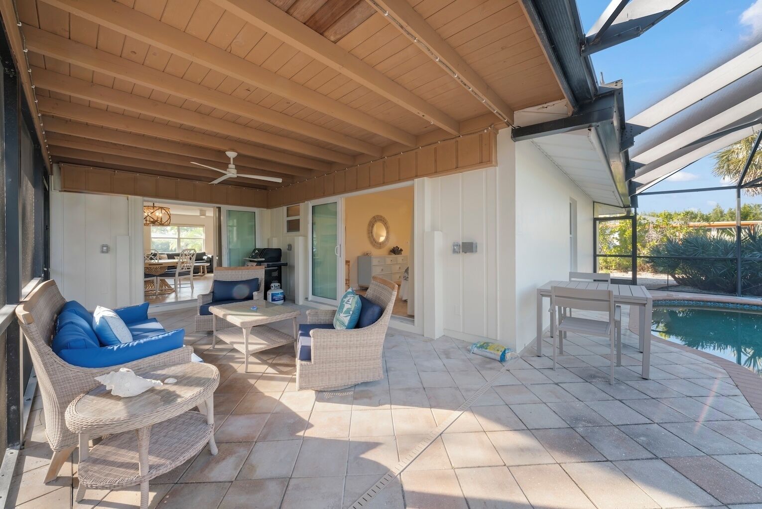 Un patio esterno coperto con mobili in vimini, una piscina e vista sul paesaggio circostante.