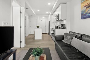 Apartamento Deluxe, 1 habitación, vistas al patio | Zona de estar | Una televisión de pantalla plana, Netflix, Hulu, servicios de streaming