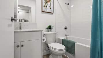 A modern bathroom with a toilet, sink, and bathtub.