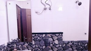 A bathroom with a white sink, a toilet, and a shower. - STAR INN (Gurugram)