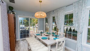 A dining area with a white table, blue plates, and a bench. - Located in Keenwick Sound with Backyard Oasis: fire pit, bar, & TV; Community Pool & Boat/Kayak launch (Selbyville)