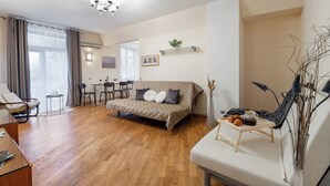 A modern living room with a sofa, a dining table, and a coffee table. - Spacious apartments near Pobedy Square (Minsk)
