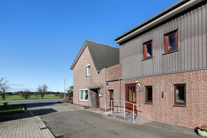 Un bâtiment à deux étages, avec une façade en briques et une partie supérieure grise.